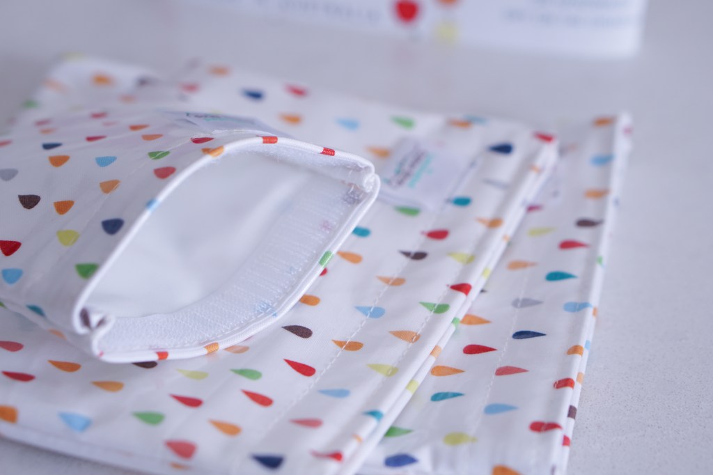 The Laminated Cotton Shop Snack Bags stacked on each other with smallest bag open to show velcro closure